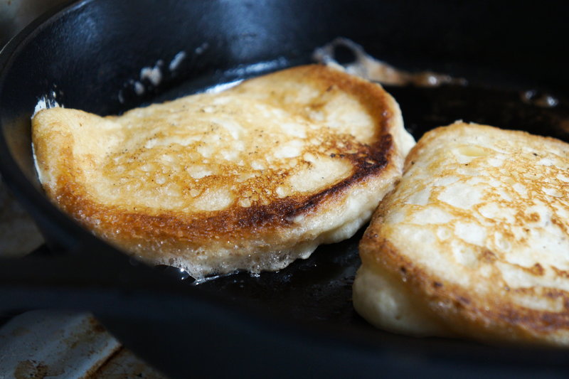 Pancakes cooking over cast iron skillet